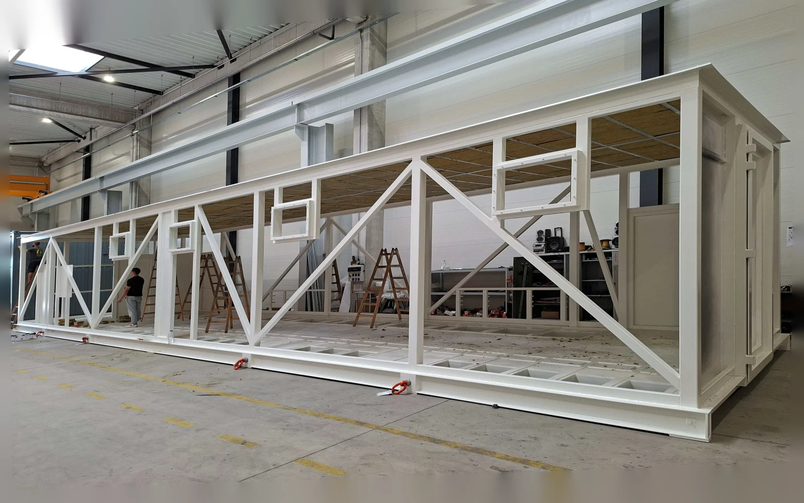 Painted steel frame of an oversized electrical substation enclosure in the workshop